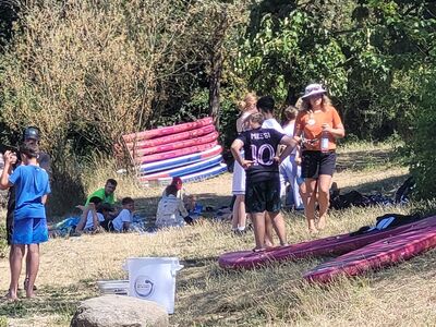 Schüler unterhalten sich in Gruppen am Ufer der Donau