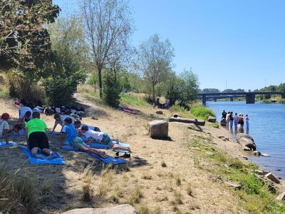Blick auf Donau und Donauufer, Schüler beim Yoga im Vordergrund