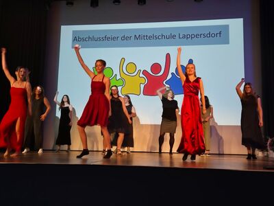 Absolventinnen führen auf der Bühne einen Tanz auf