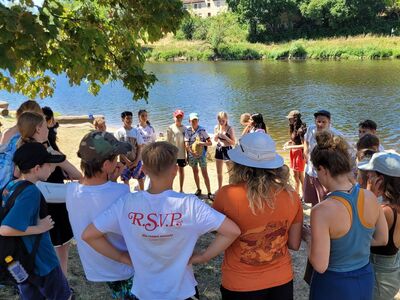 Schüler in einer Diskussionsrunde am Donauufer